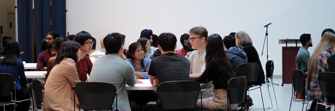 students sitting with an employer at a networking event