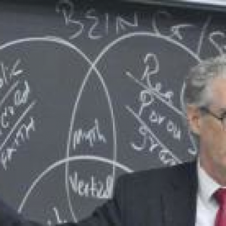 Professor lecturing in front of a chalkboard