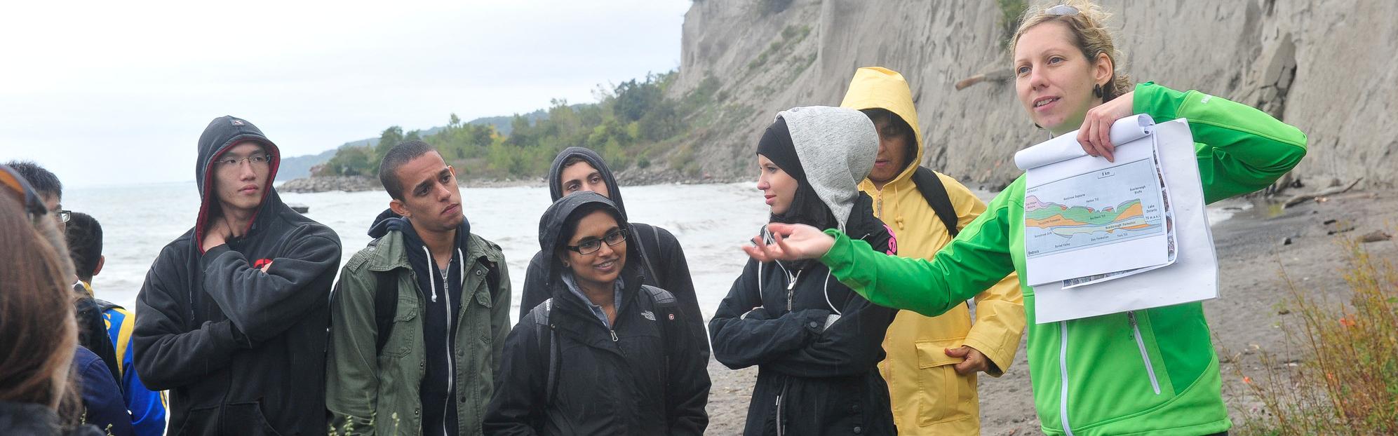 Students on a field trip at the base of the Scarborough bluffs examining a chart