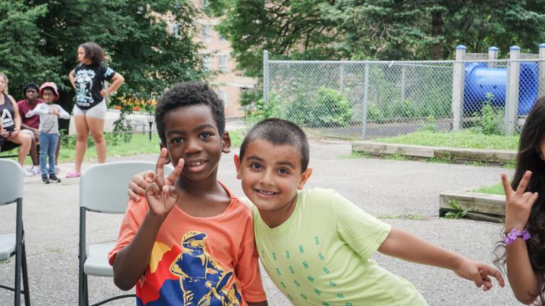 Two children from All Stars Community Outreach in Scarborough smiling in a playground