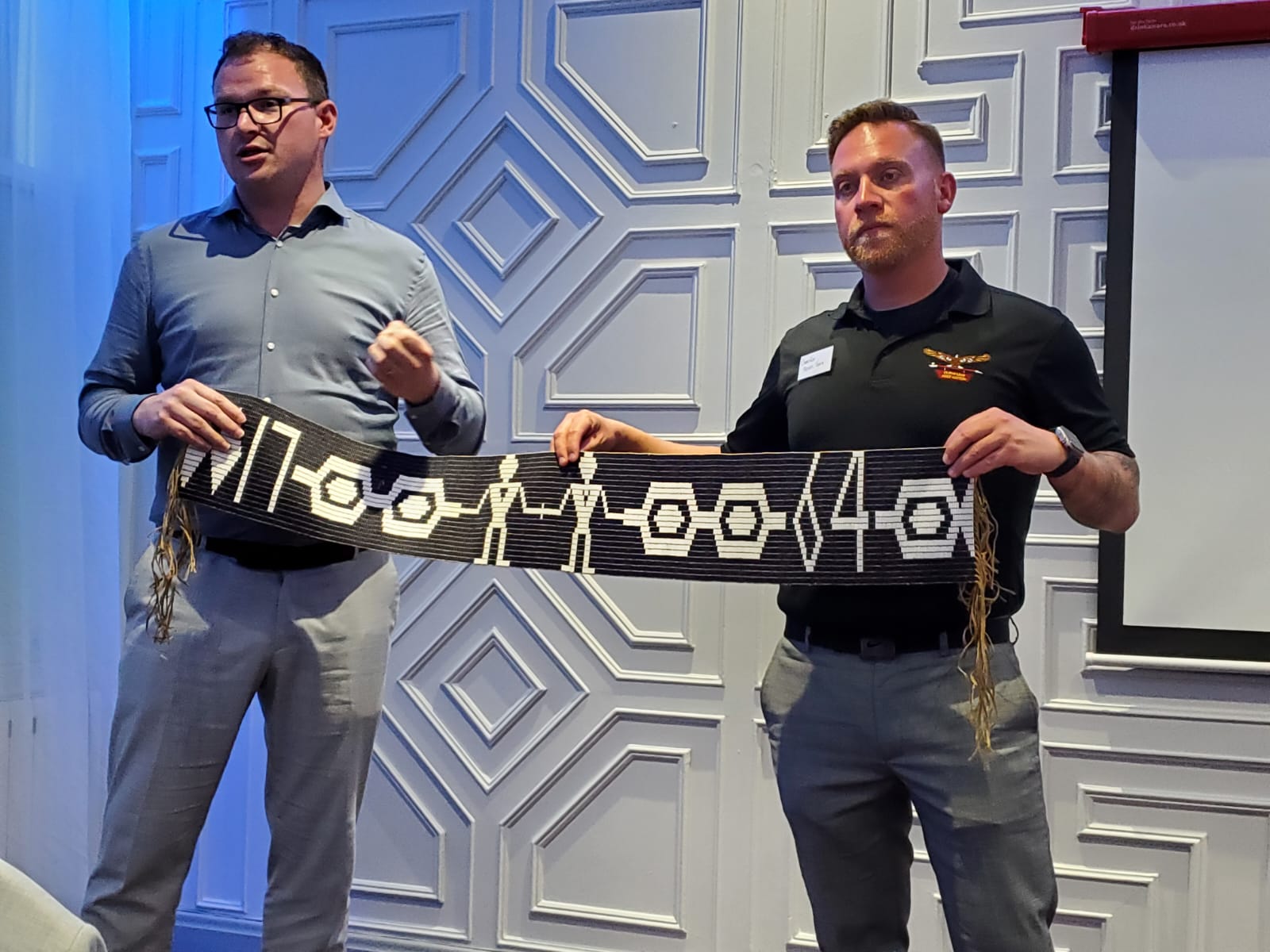 Photo of the replica of the treaty of Niagara wampum belt- Left to Right: Chad Cowie (Assistant Professor/from Pamitaashkodeyong/Hiawatha First Nation), Steve Tom’s (Elected Councillor for O’Shkiigmong/Curve Lake First Nation)