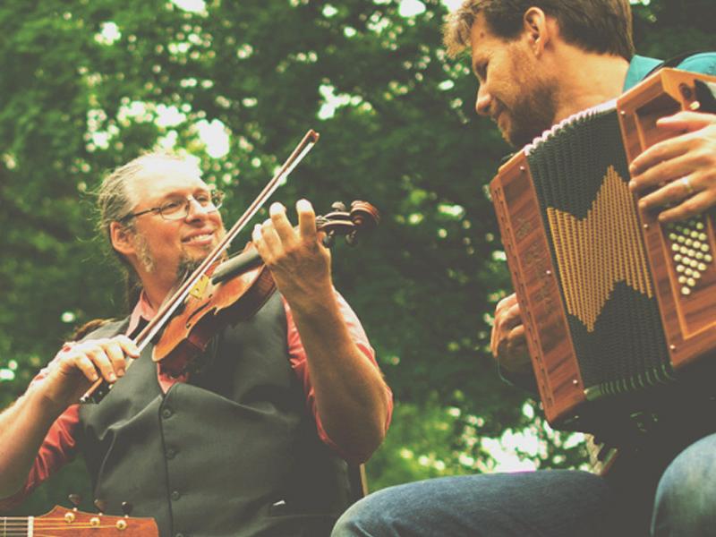 three people playing instruments outdoors