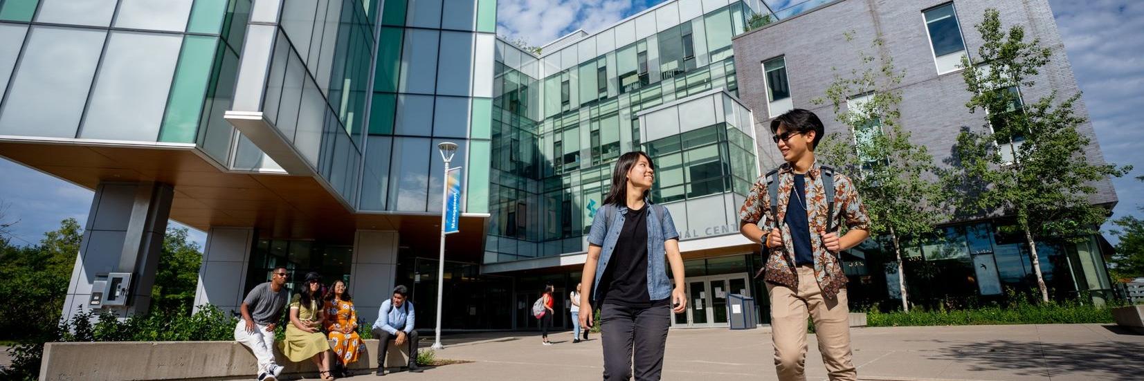 Two students walking outside Instructional Centre building at U of T Scarborough