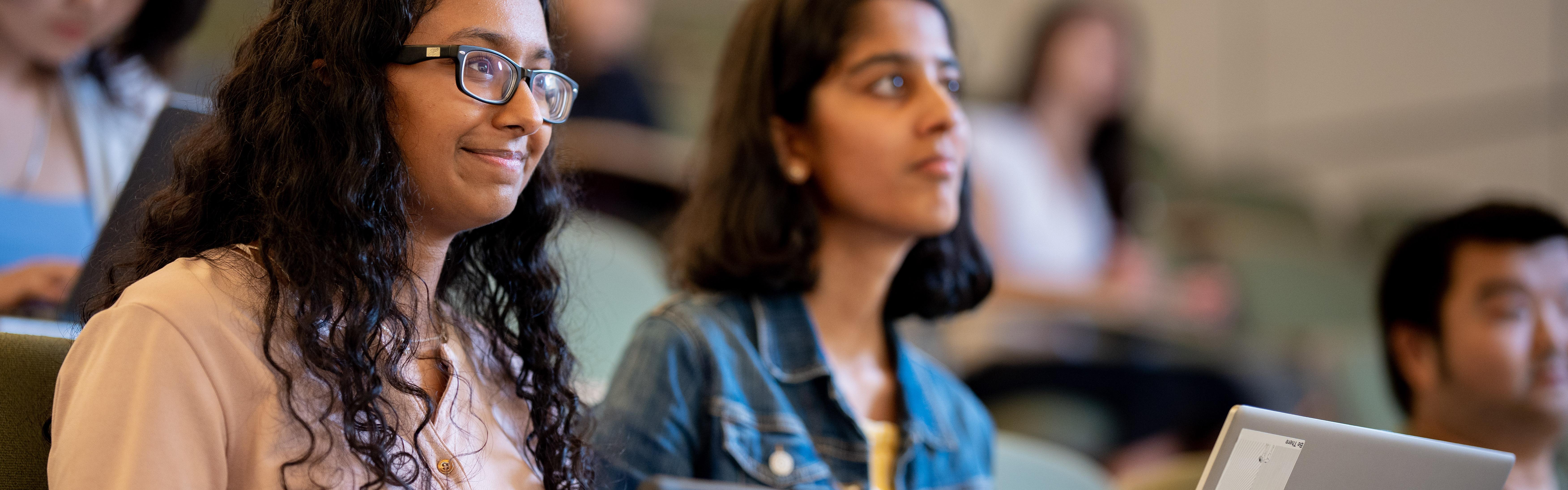 A close shot of two students listening in a lecture