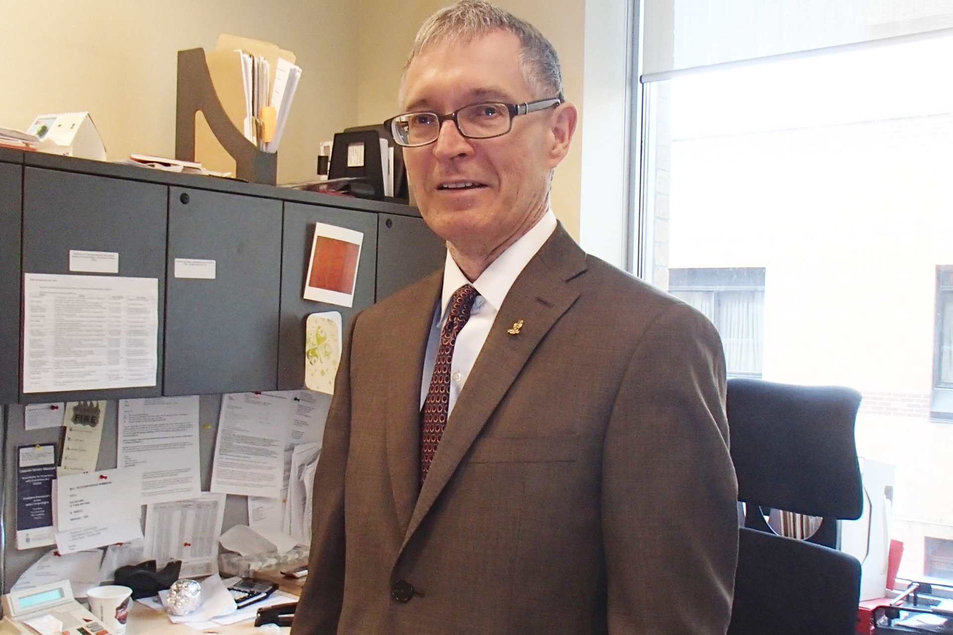 Jim Hartley wears a suit in his U of T office, circa 2014