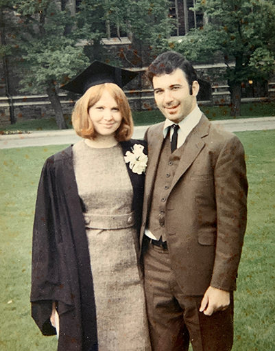 Janice Sierakowski in a cap and gown with Stefan Sierakowski in a suit stand in front of University College circa June 1969