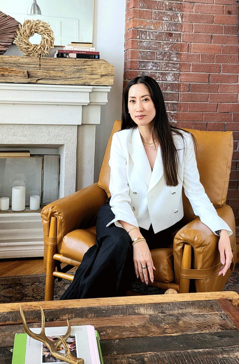 Elina Chow sitting against a mantelpiece