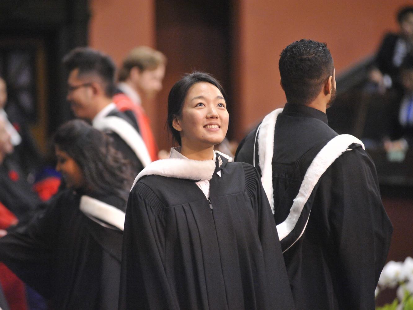 Student in regalia at convocation hall 