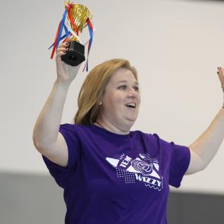 a member of the leadership team with a victory trophy