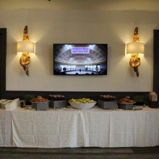 Breakfast spread with Indigenous House displayed on a digital screen