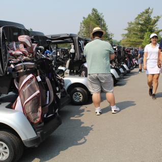 players walk next to golf carts