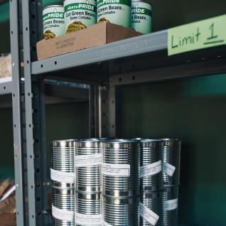 silver cans of food on a shelf, with a note saying Limit 1