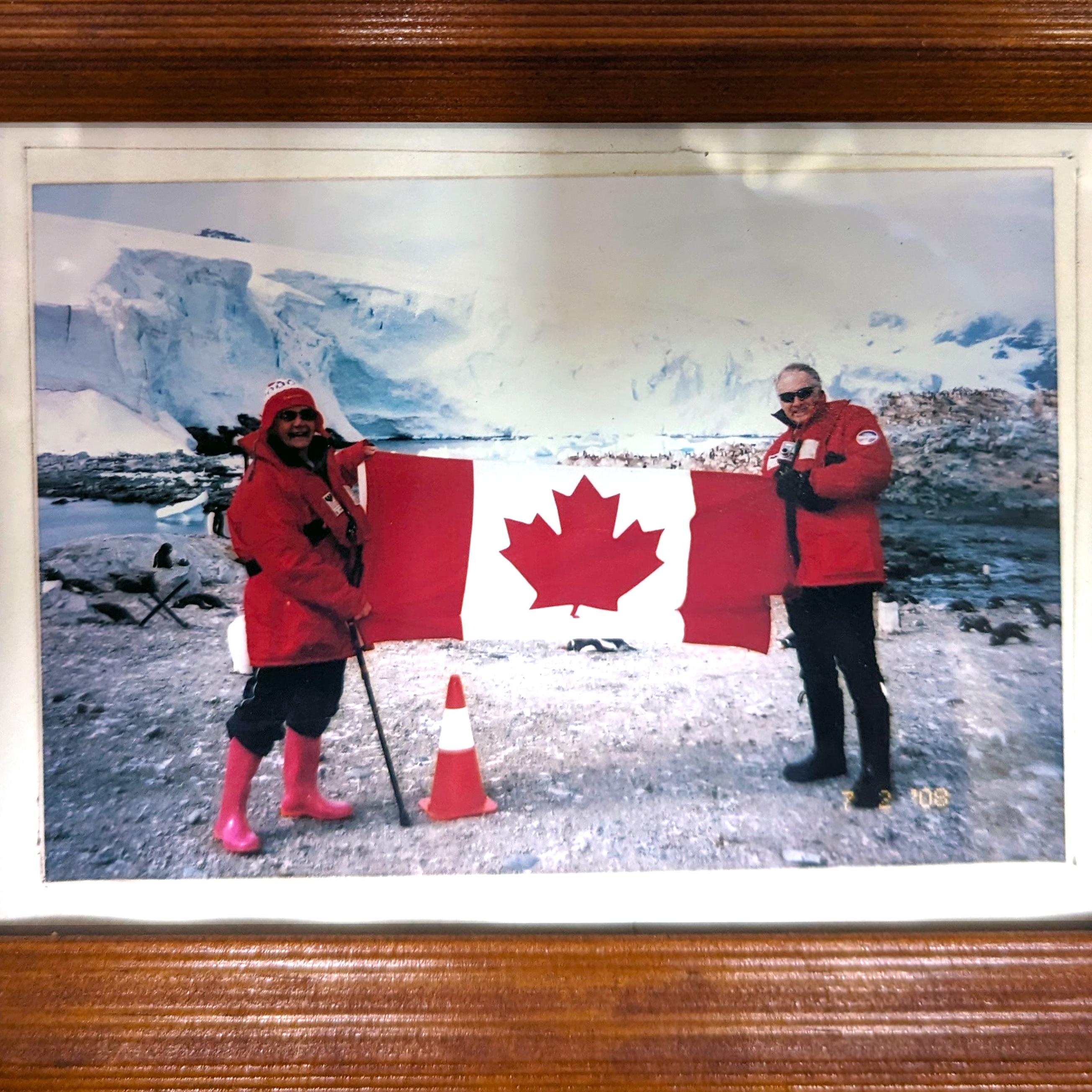 Janet with a friend holding a canadian flag in Antarctica