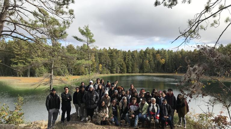 Students stand at the side of a lake in Petroglyphs Provincial Park