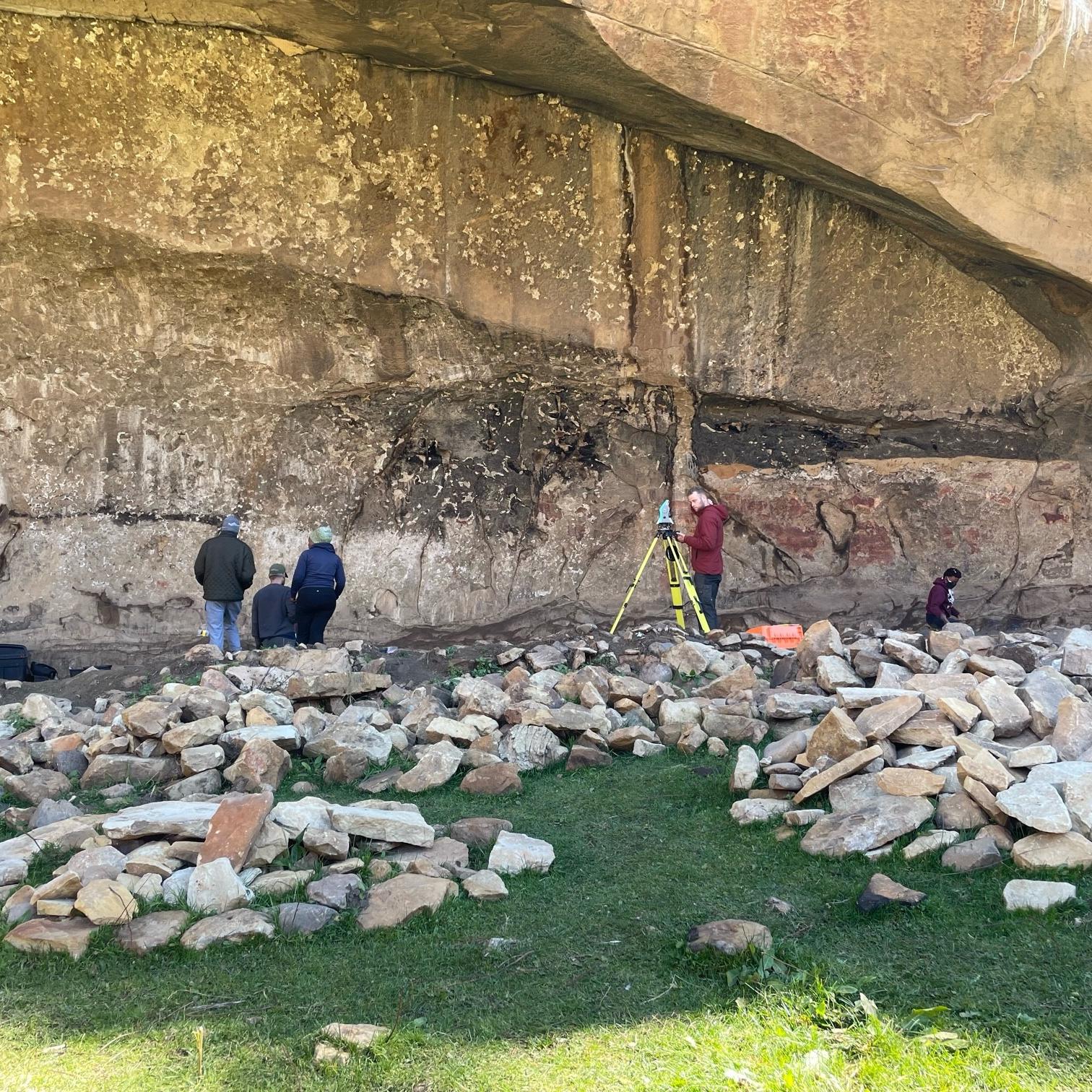 UTSC archaeologists surveying inside the rock shelter at Ha Soloja. 