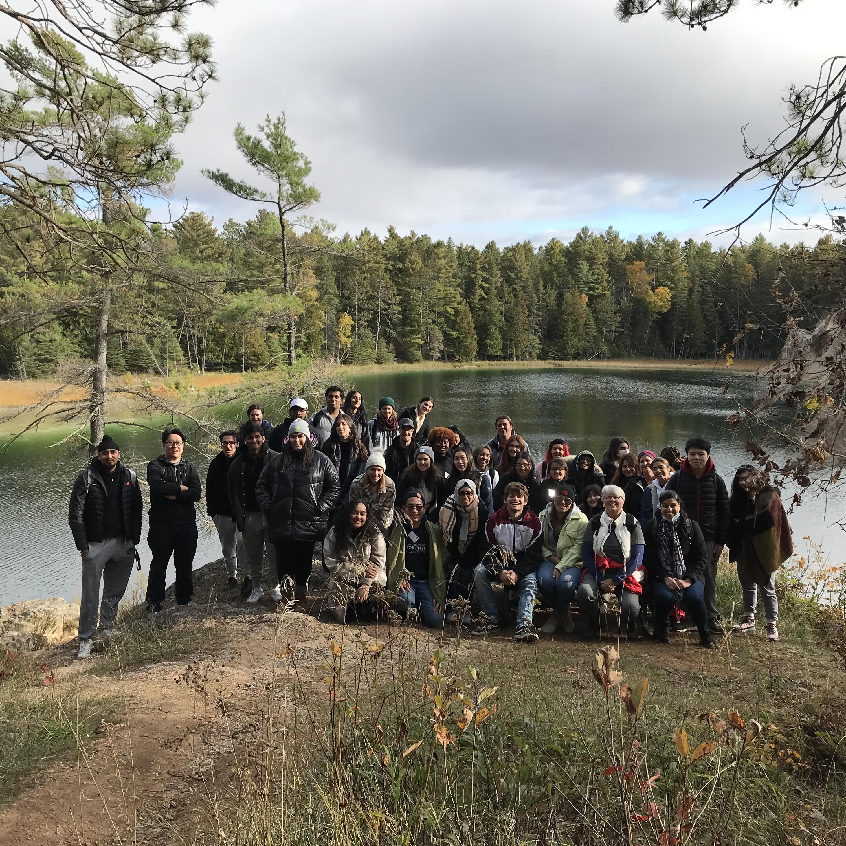 A group shot of UTSC students standing by a lake in Petroglyphs Provincial Park