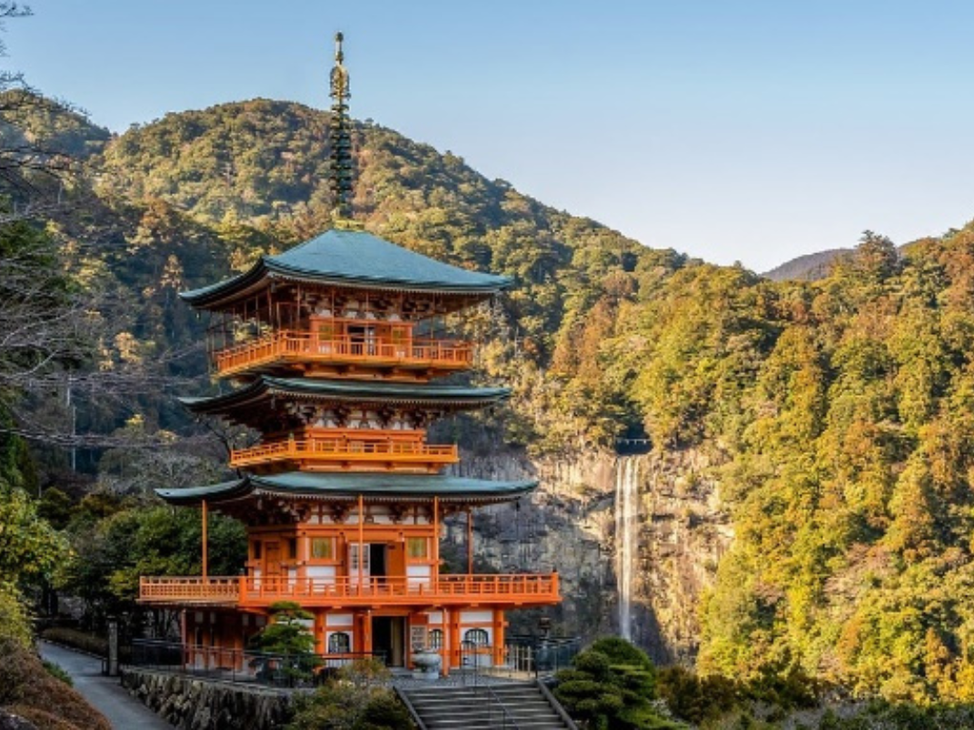 A pagoda against a forested mountain backdrop