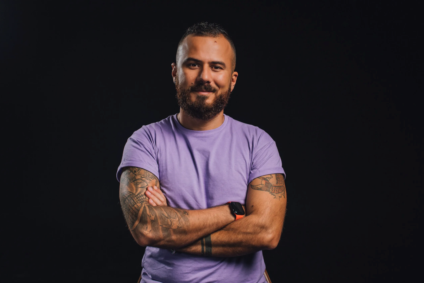 Author bio photo: Danny in a purple t-shirt, arms crossed, smiling