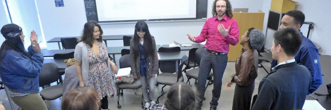 Prof. Daniel Tysdal standing with his students in the classroom