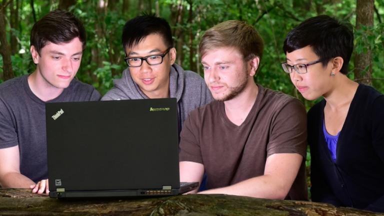 A group of students collaborating using one laptop