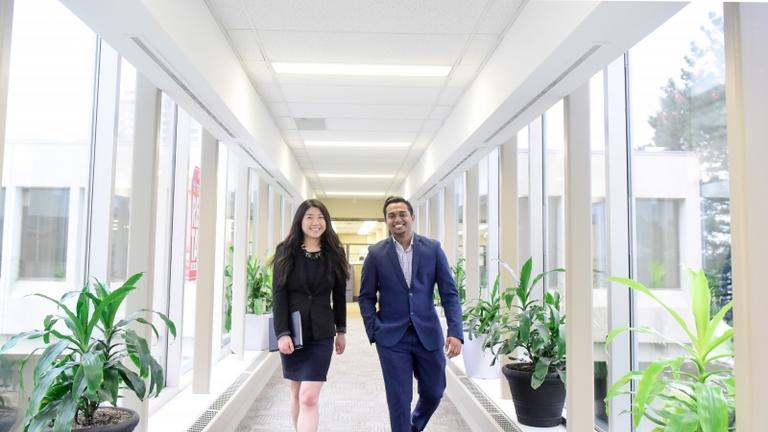 Two formally dressed students walking in a hallway