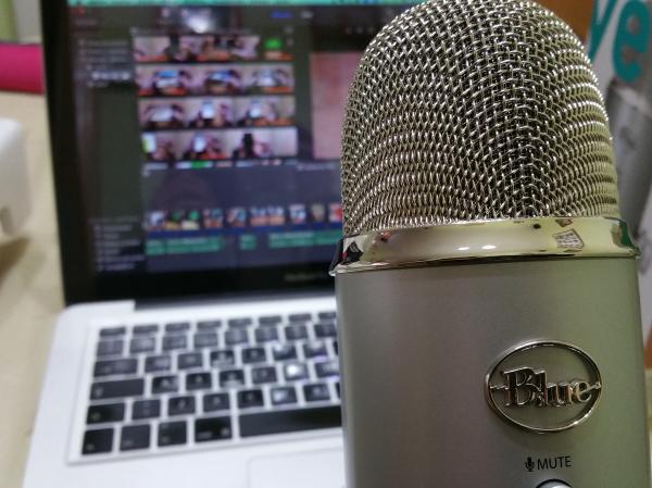 Podcast mic with a laptop in the background