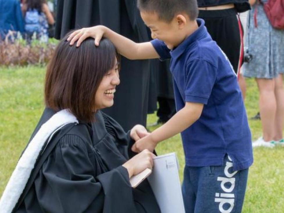 child patting graduate's head