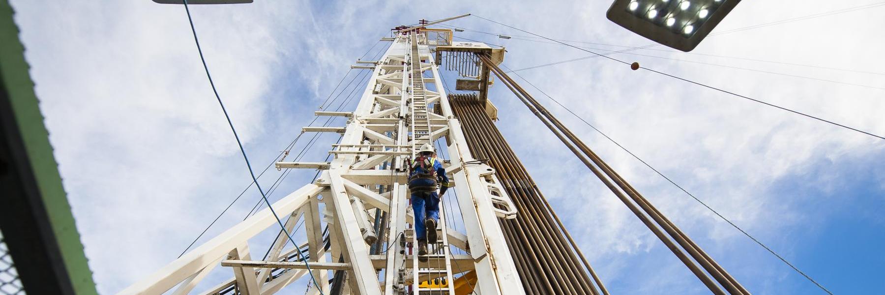 A worker climbs up a fracking rig