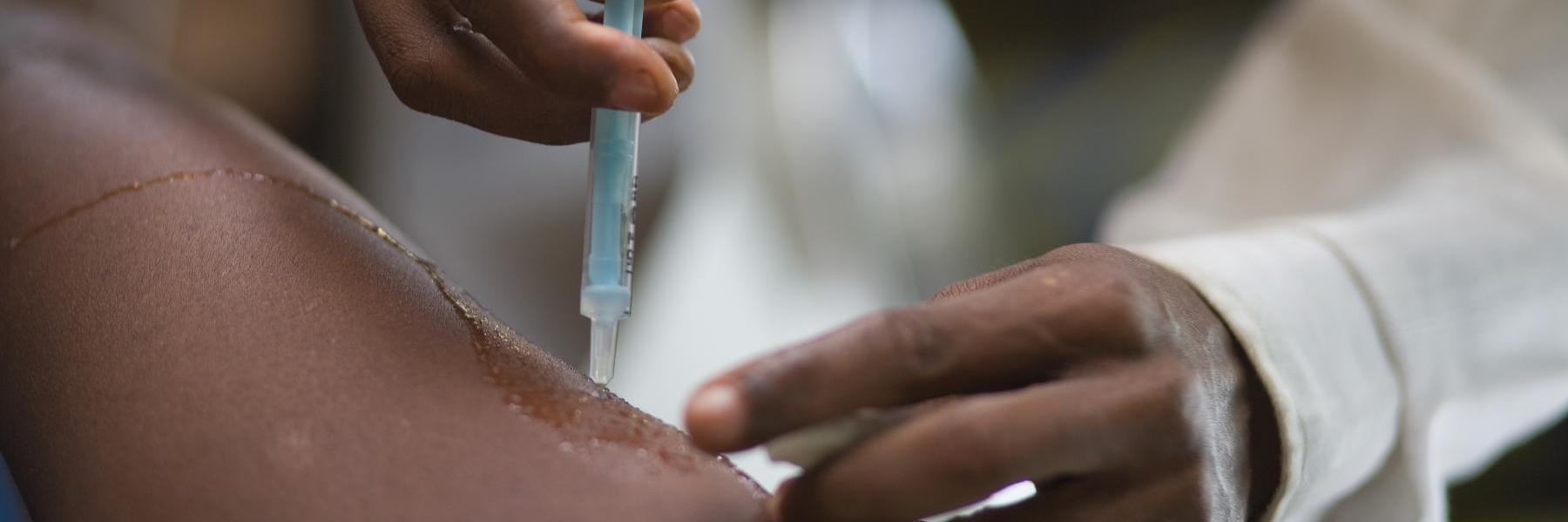 Close-up of an person's arm being injected with a vaccine in the Democratic Republic of Congo