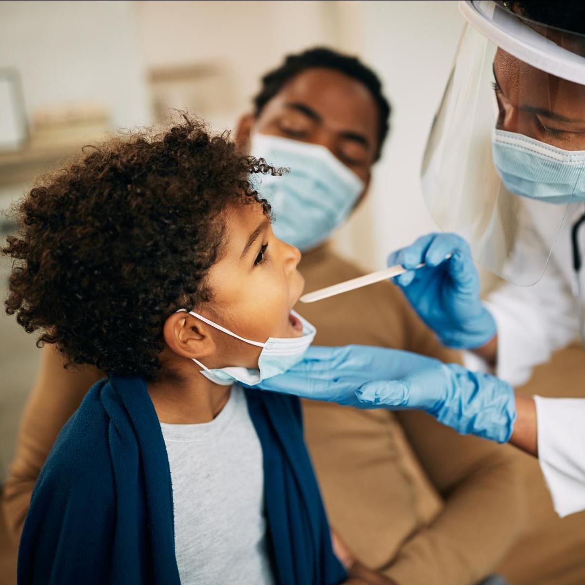 A young Black boy is examined by a Black doctor
