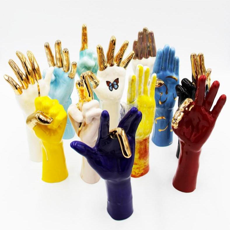 A collection of coloured ceramic hands making signs