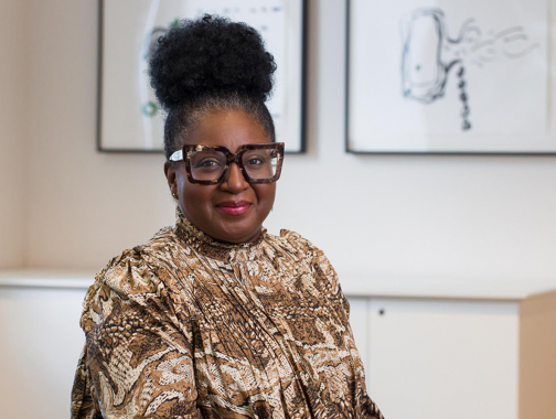 Professor Notisha Massaquoi, a black woman in a gold-coloured blouse with stylish glasses