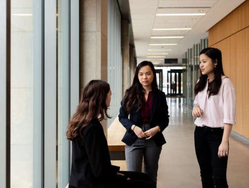 students chatting on campus hallway