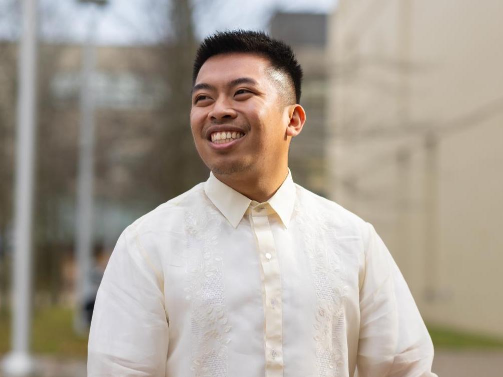 A portrait shot of Alfonso Ralph Mendoza Manalo with the U of T Scarborough campus behind