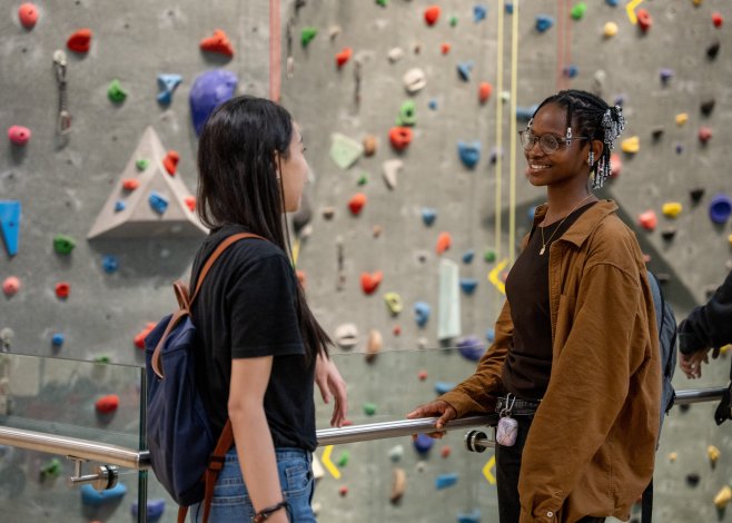 Two students talking by the climbing wall in the Toronto Pan Am Sport Centre on the U of T Scarborough campus