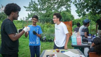 UTSC student and Campus Farm volunteer interacts with high school students visiting