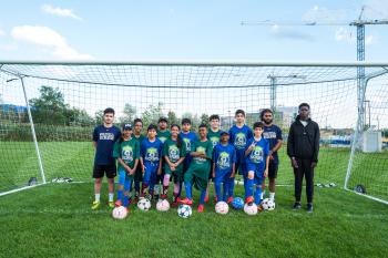 Students and staff pose a photo at a soccer sports program