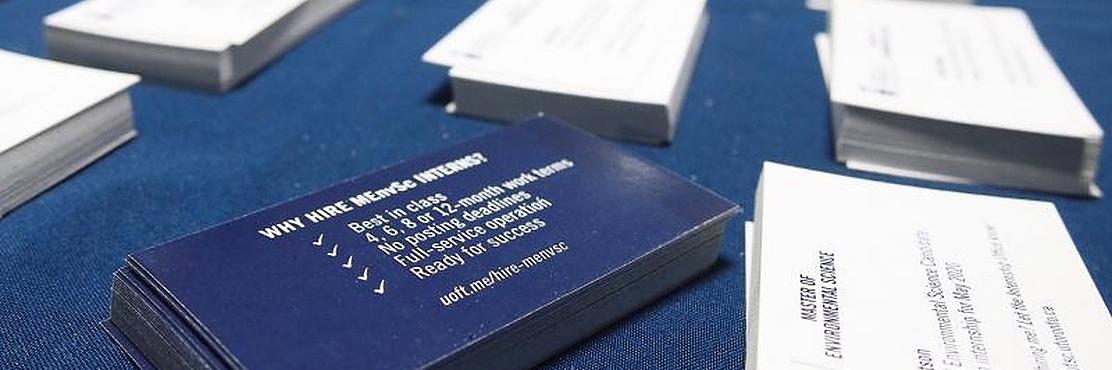 Student business cards laid on a blue table