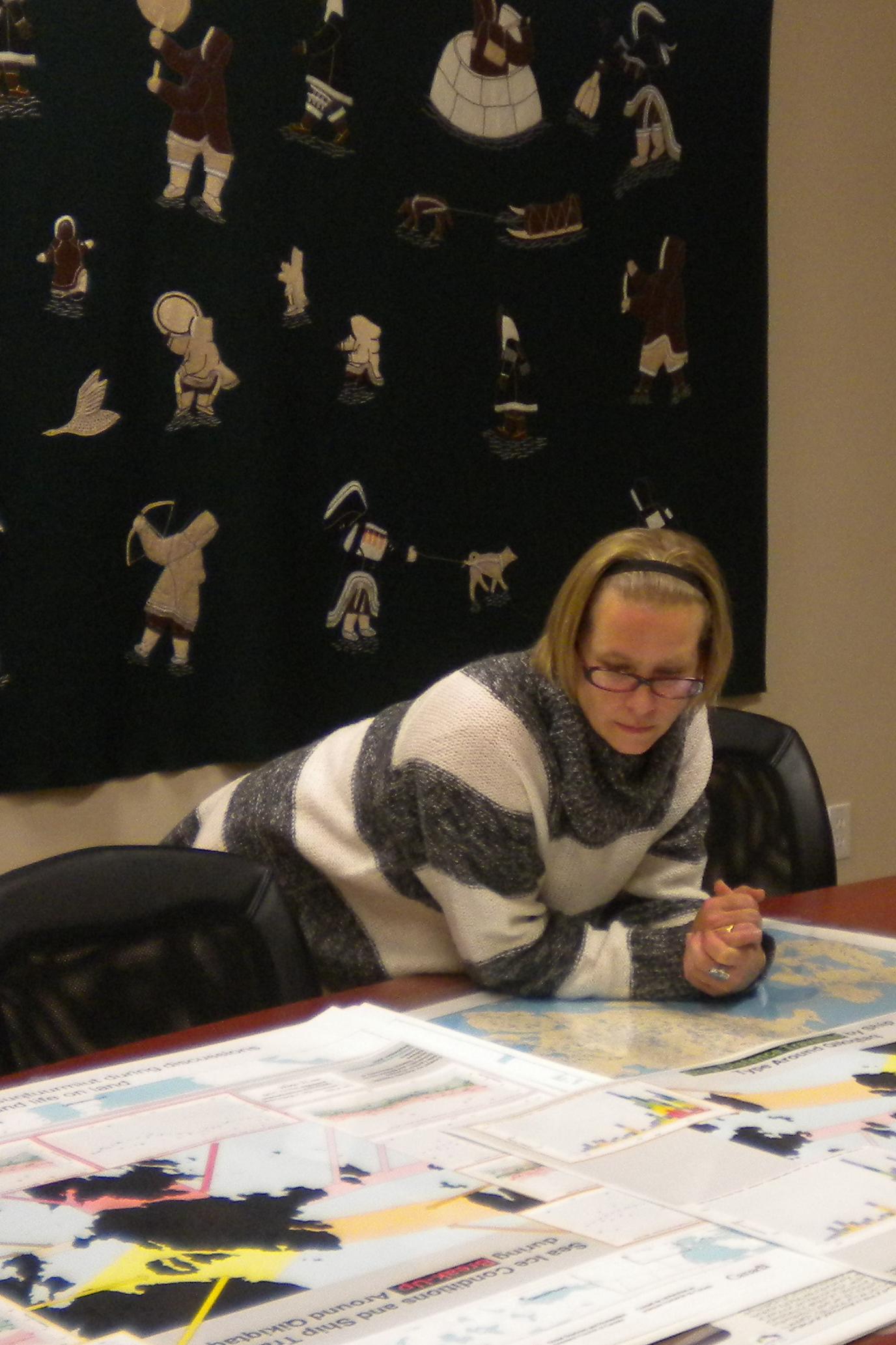 Photo of Cheryl Ann Johnson looking over research posters on a table