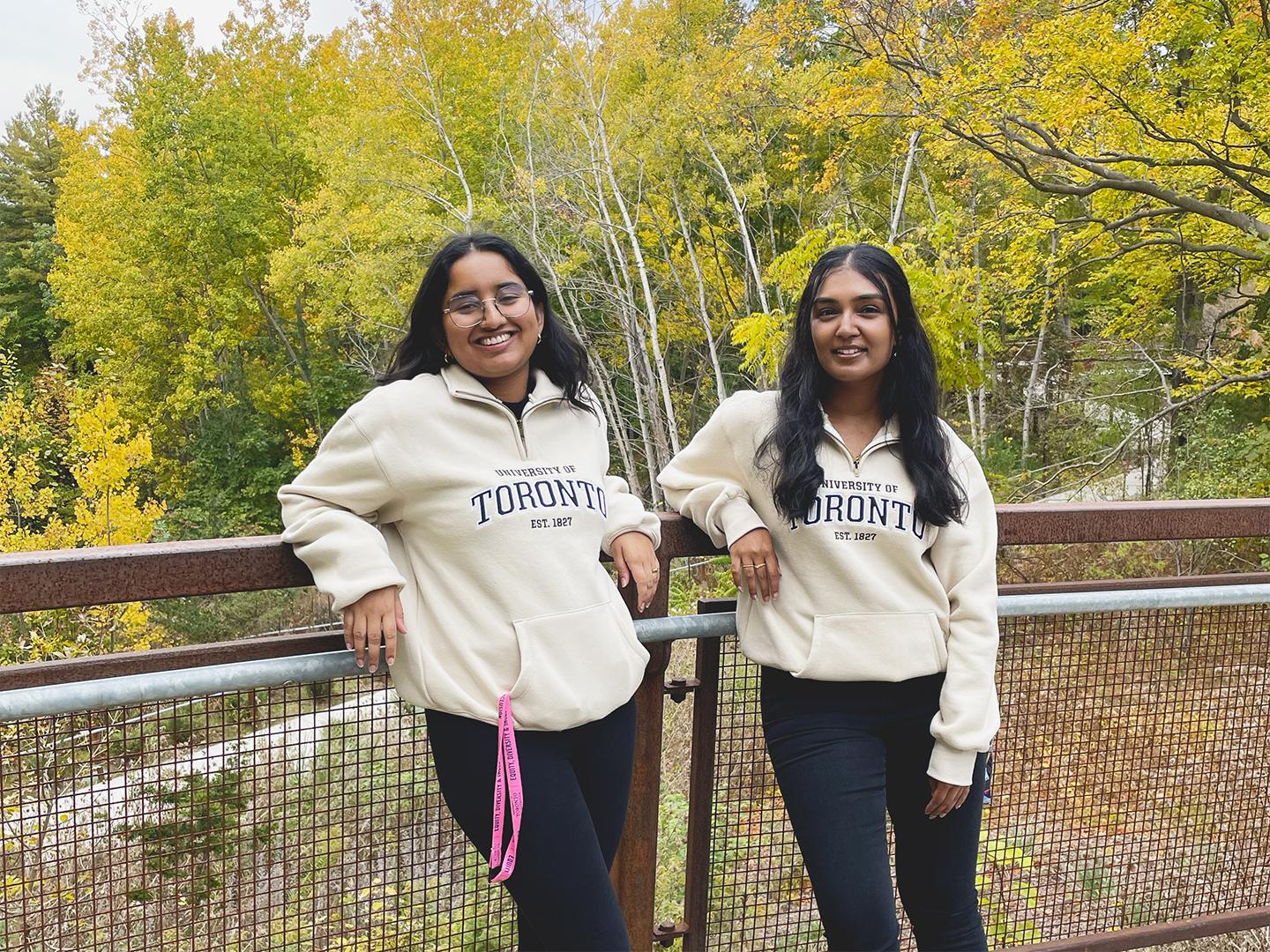 Students standing in front of fall foliage on campus