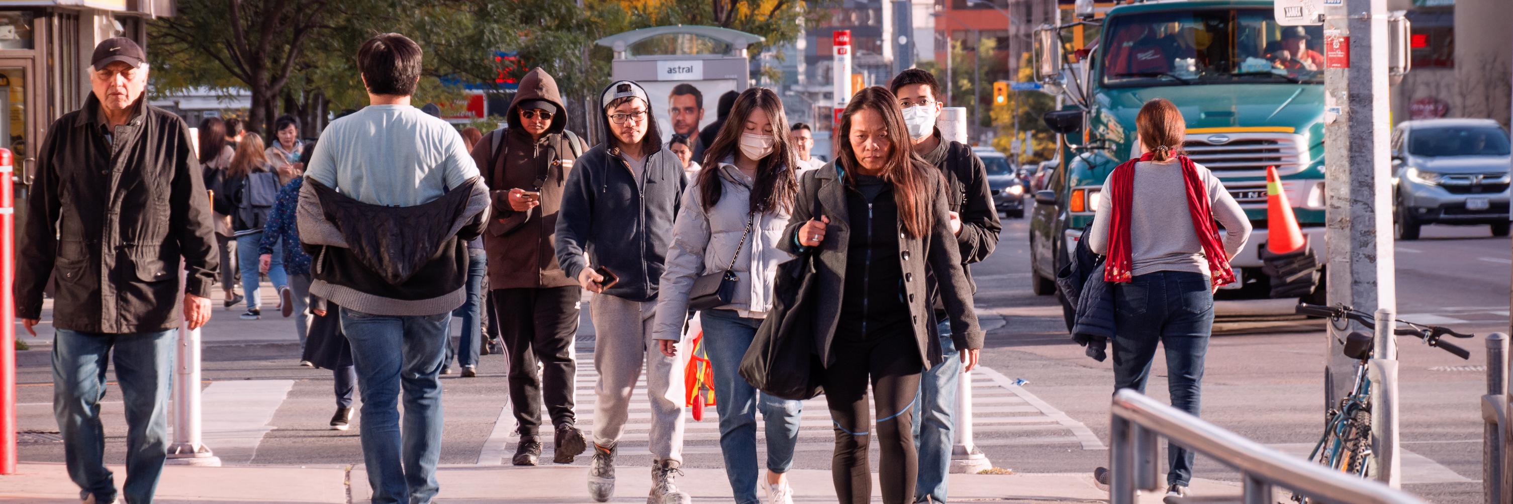 A crowd of people walking in Toronto, early evening, fall 2022