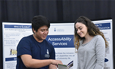 Student staff showing a student a booklet