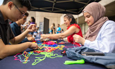 Students making bracelets at Welcome Day