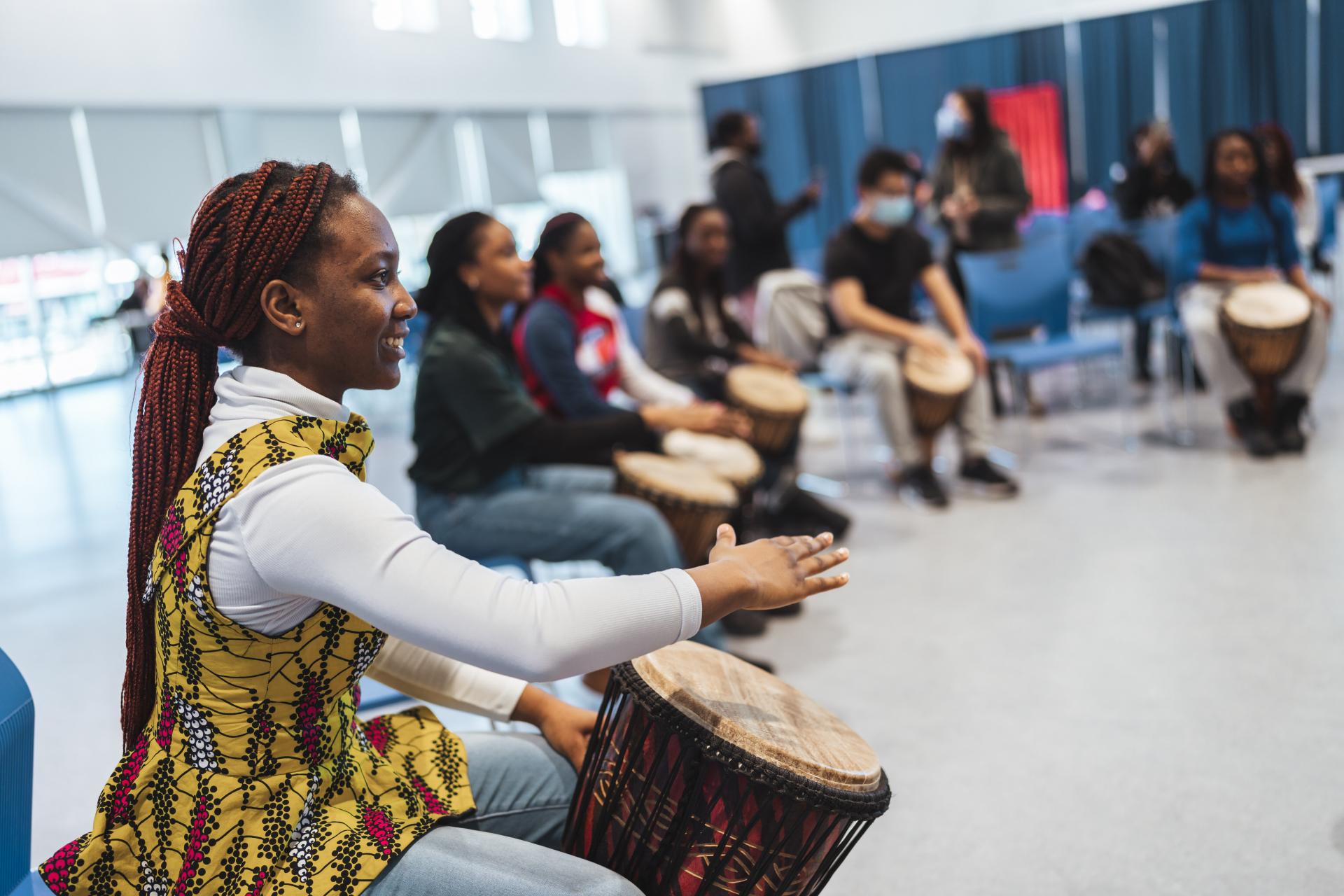 Black UTSC students sitting in a drumming circle