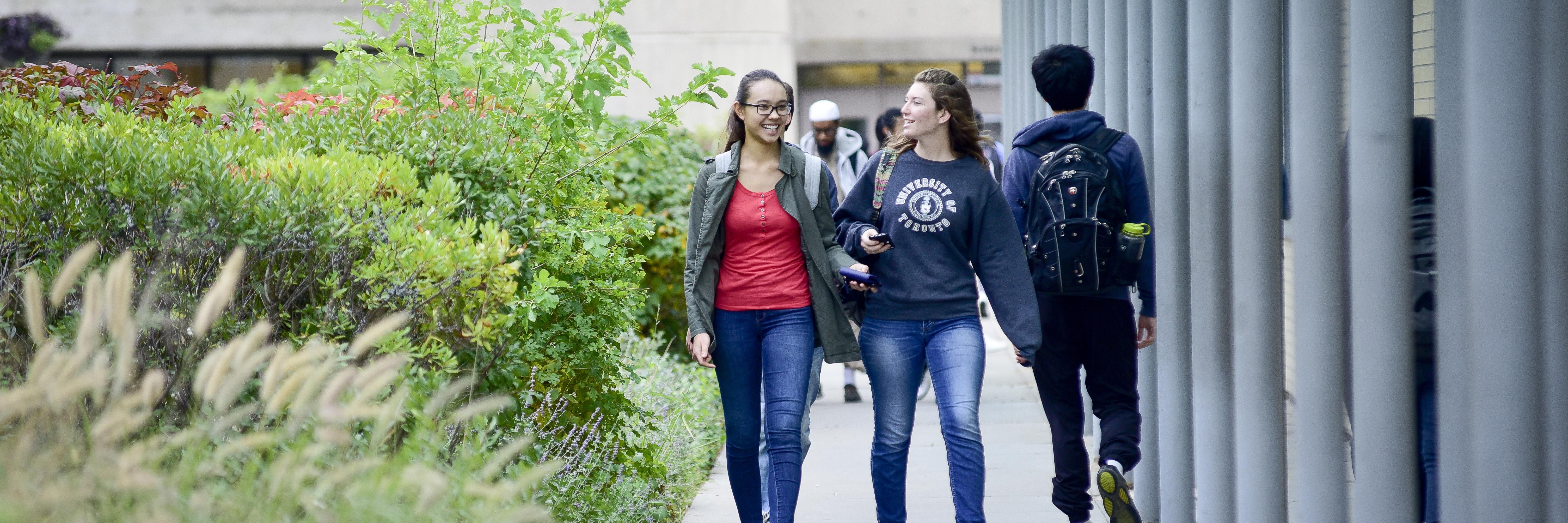 Two students walk down a path at UTSC