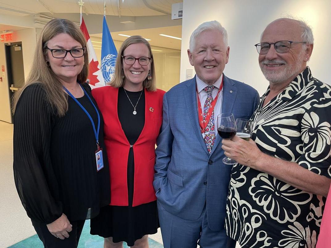 4 members of the Canadian Delegation smiling at the camera
