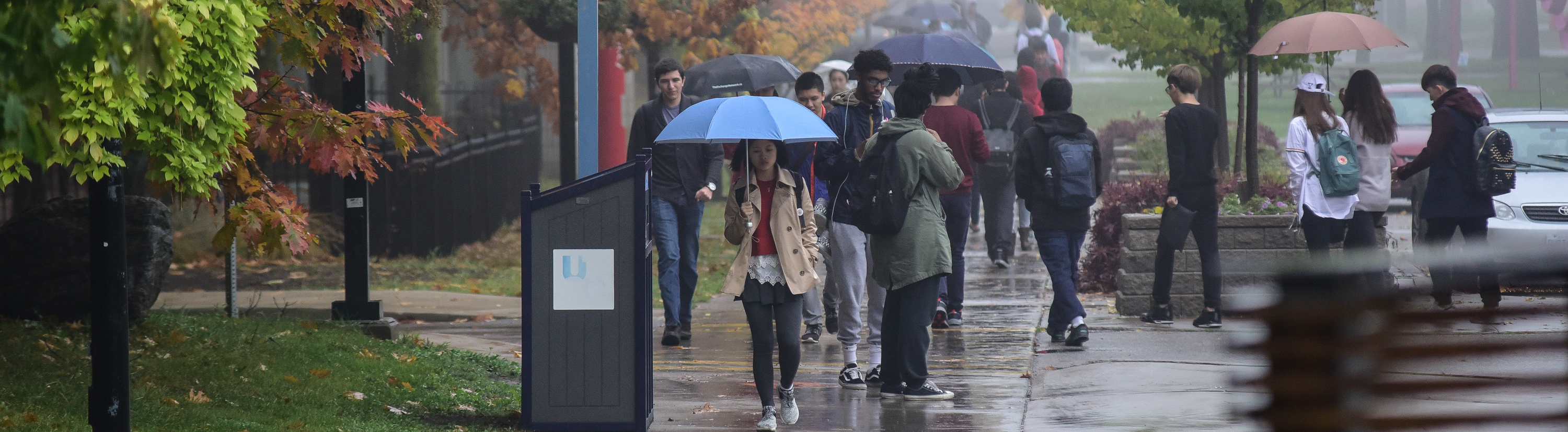 Students walking at UTSC in the rain